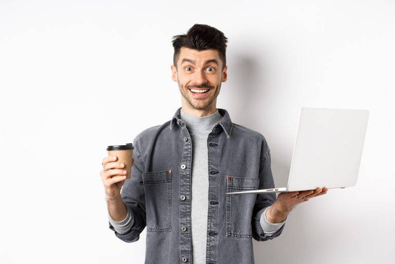 Happy energized guy drinking coffee and working