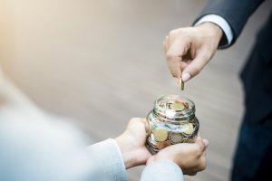 begging - coin put in a glass jar